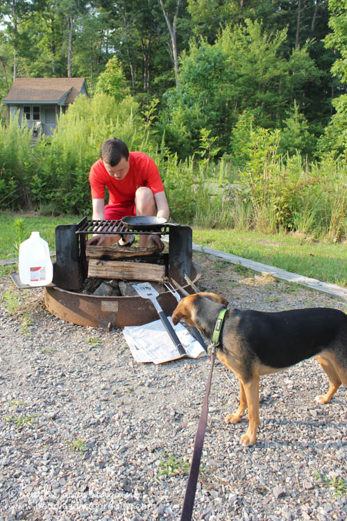 Luna helps set up the grill while camping